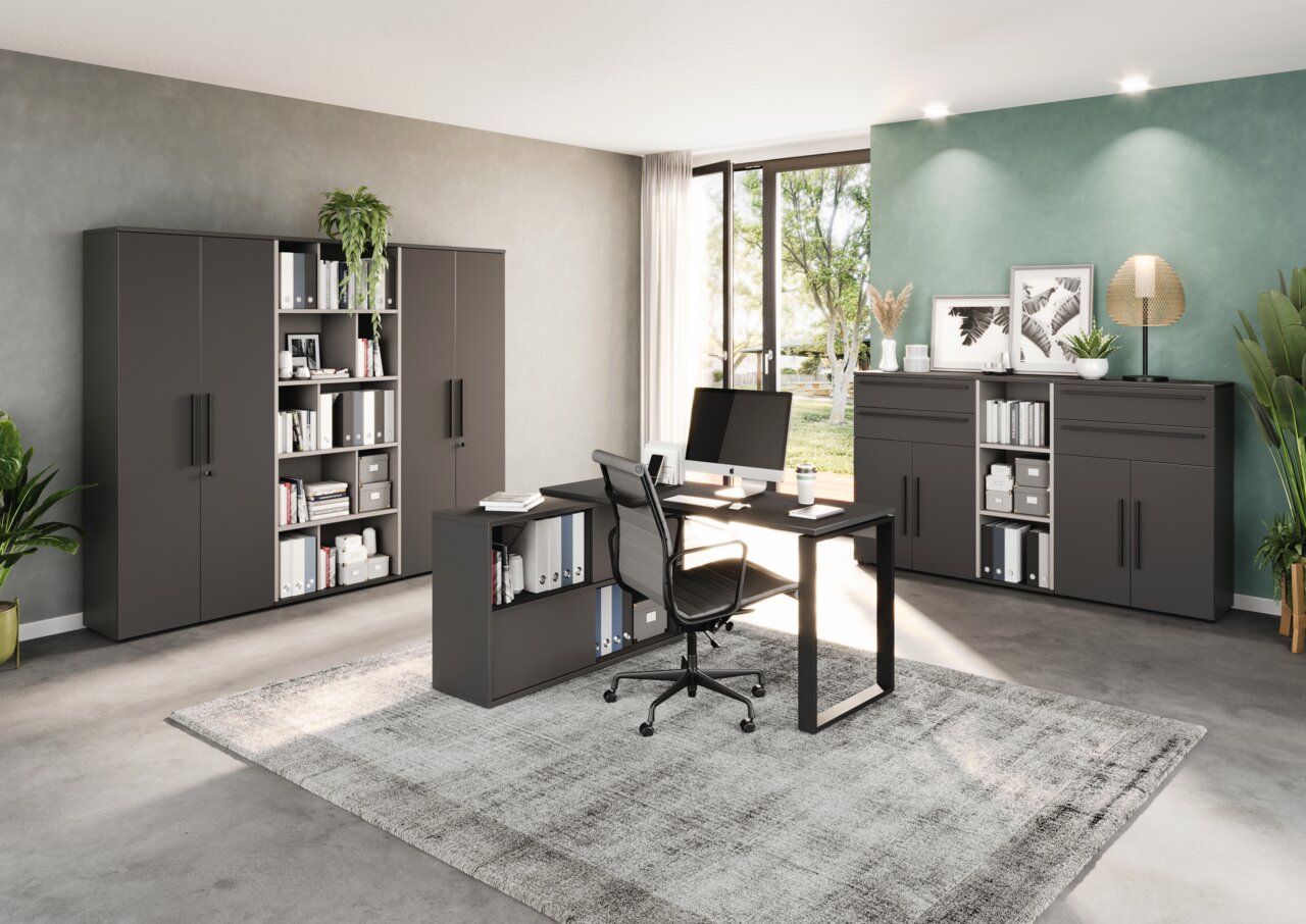 Novel Aktenschrank 5OH breit RENTON Moderne Büromöbel in einem hellen Raum mit großem Fenster, bestehend aus einem Winkelschreibtisch, mehreren Aktenschränken und Regalen. Perspektive von vorne links.