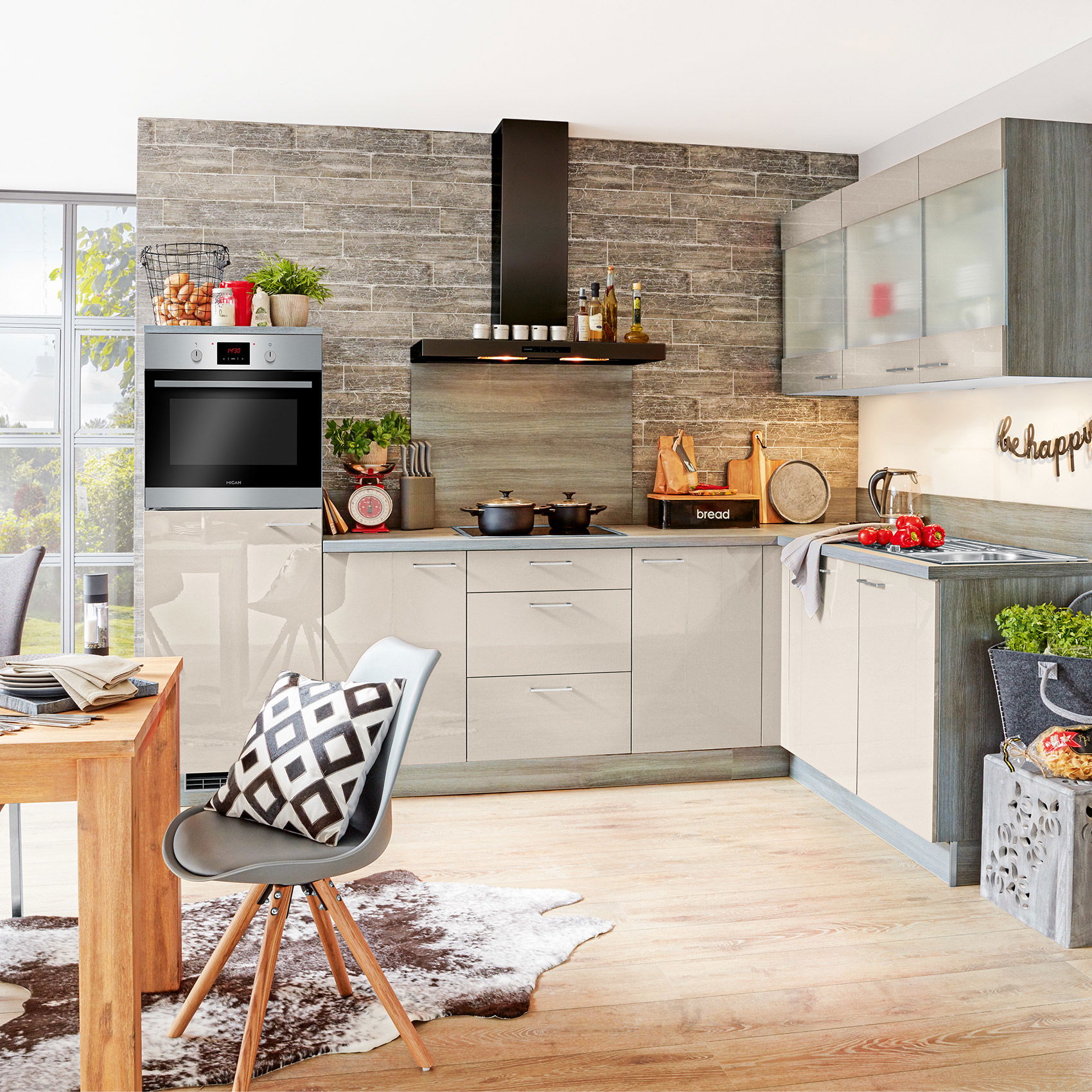 Moderne Küche mit Einbaubackofen, Dunstabzugshaube, Kochfeld und hellen Arbeitsflächen.