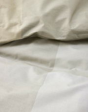 Nahaufnahme von beiger Bettwäsche mit leichtem Faltenwurf, Draufsicht