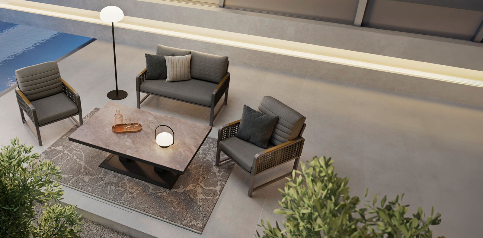 Moderne Loungegarnitur mit zwei Sesseln, einem Sofa und einem Tisch in einer stilvollen Außenumgebung, aus der Vogelperspektive betrachtet.