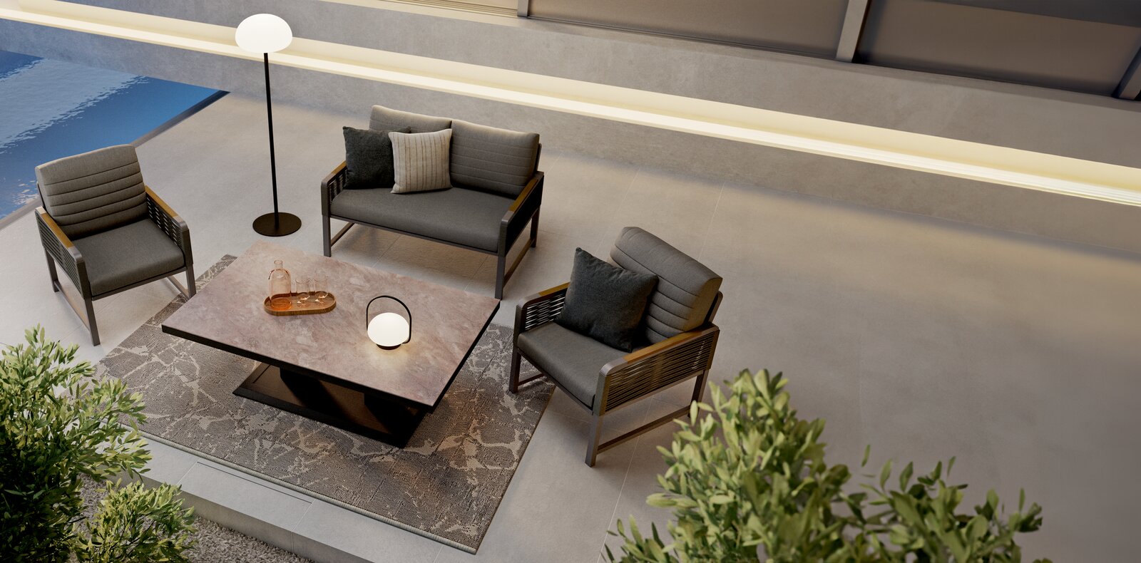 Moderne Loungegarnitur mit zwei Sesseln, einem Sofa und einem Tisch in einer stilvollen Außenumgebung, aus der Vogelperspektive betrachtet.