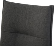 Nahaufnahme der dunkelgrauen, strukturierten Stoff-Polsterlehne eines Stuhls mit leichter Wölbung, frontal aus leicht schräger Perspektive