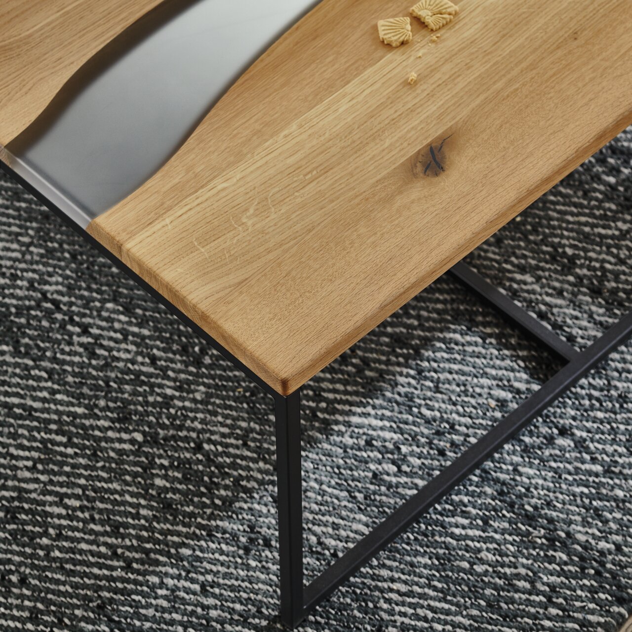 Moderner Couchtisch mit Holzplatte und schwarzem Metallgestell, von oben betrachtet.