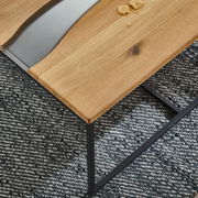 Moderner Couchtisch mit Holzplatte und schwarzem Metallgestell, von oben betrachtet.