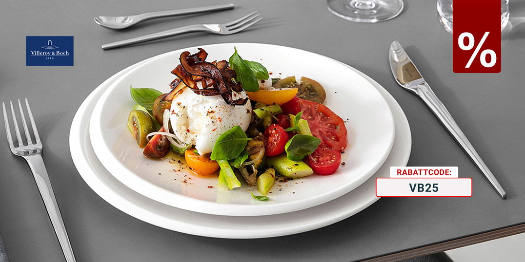 Modern gedeckter Esstisch mit weißem Villeroy & Boch Geschirr, Edelstahlbesteck, Weißweinglas und Burrata-Tomatensalat auf grauer Tischplatte.