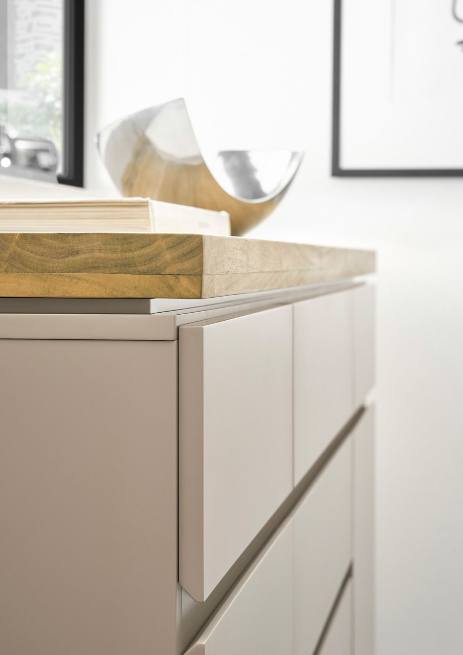 Nahaufnahme eines modernen Sideboards mit Holzplatte und eleganten, glatten Fronten, seitliche Perspektive