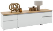 Modernes weißes Sideboard/Lowboard mit Holzplatte und grifflosen Fronten, dekoriert mit Skulptur, Glasflasche, Schale und Tischlampe; Ansicht schräg von vorn (leicht von links) auf weißem Hintergrund.