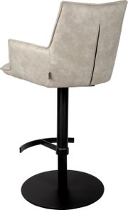 Beiger, gepolsterter Barstuhl mit Armlehnen und hoher Rückenlehne auf schwarzem Metall-Standfuß, seitliche Rückansicht (leicht von hinten).