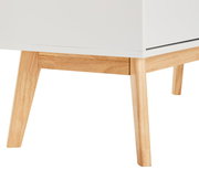 Nahaufnahme eines weißen Highboards mit hellen Holzbeinen, seitliche Perspektive