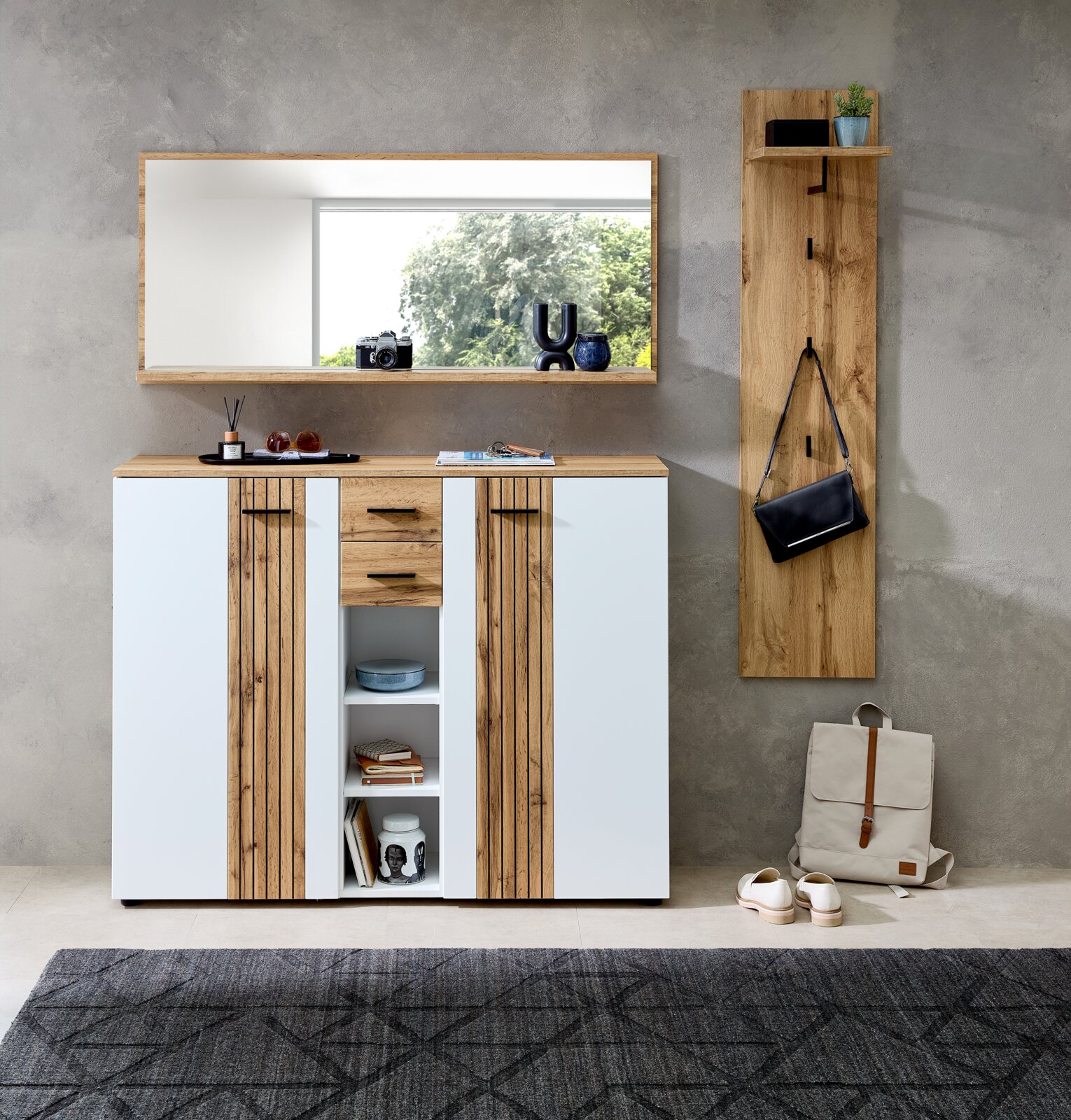 Großer rechteckiger XL-Spiegel an der Wand über einem modernen Sideboard mit Holz- und Weißakzenten, daneben eine Garderobenleiste mit Haken und Ablage, Perspektive von vorne.