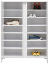 Weißer Schuhschrank mit mehreren Fächern, gefüllt mit verschiedenen Schuhen, aus frontaler Perspektive.