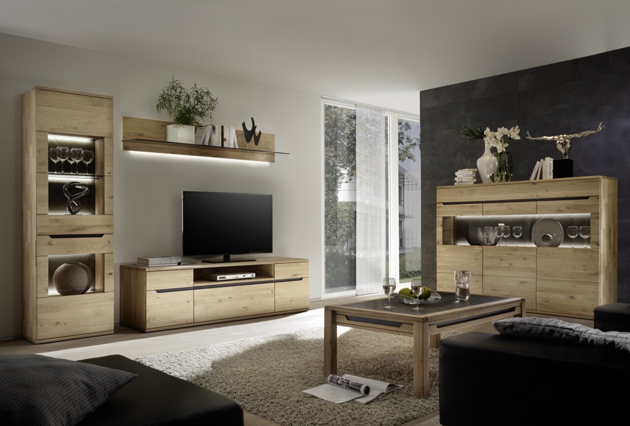 Moderne Wohnzimmer-Wandkombination aus Holz in einem hellen Raum mit großen Fenstern, bestehend aus einem TV-Schrank, einem Regal und einem Schrank, seitliche Perspektive.