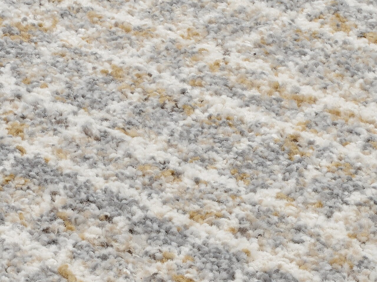 Nahaufnahme eines Frisé-Teppichs mit einer Mischung aus weißen, grauen und beigen Fasern.
