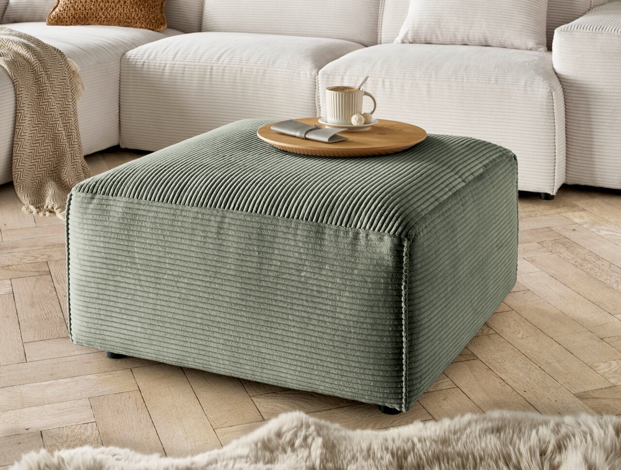 Grüner Hocker aus Cordstoff in einem Wohnzimmer, seitliche Perspektive