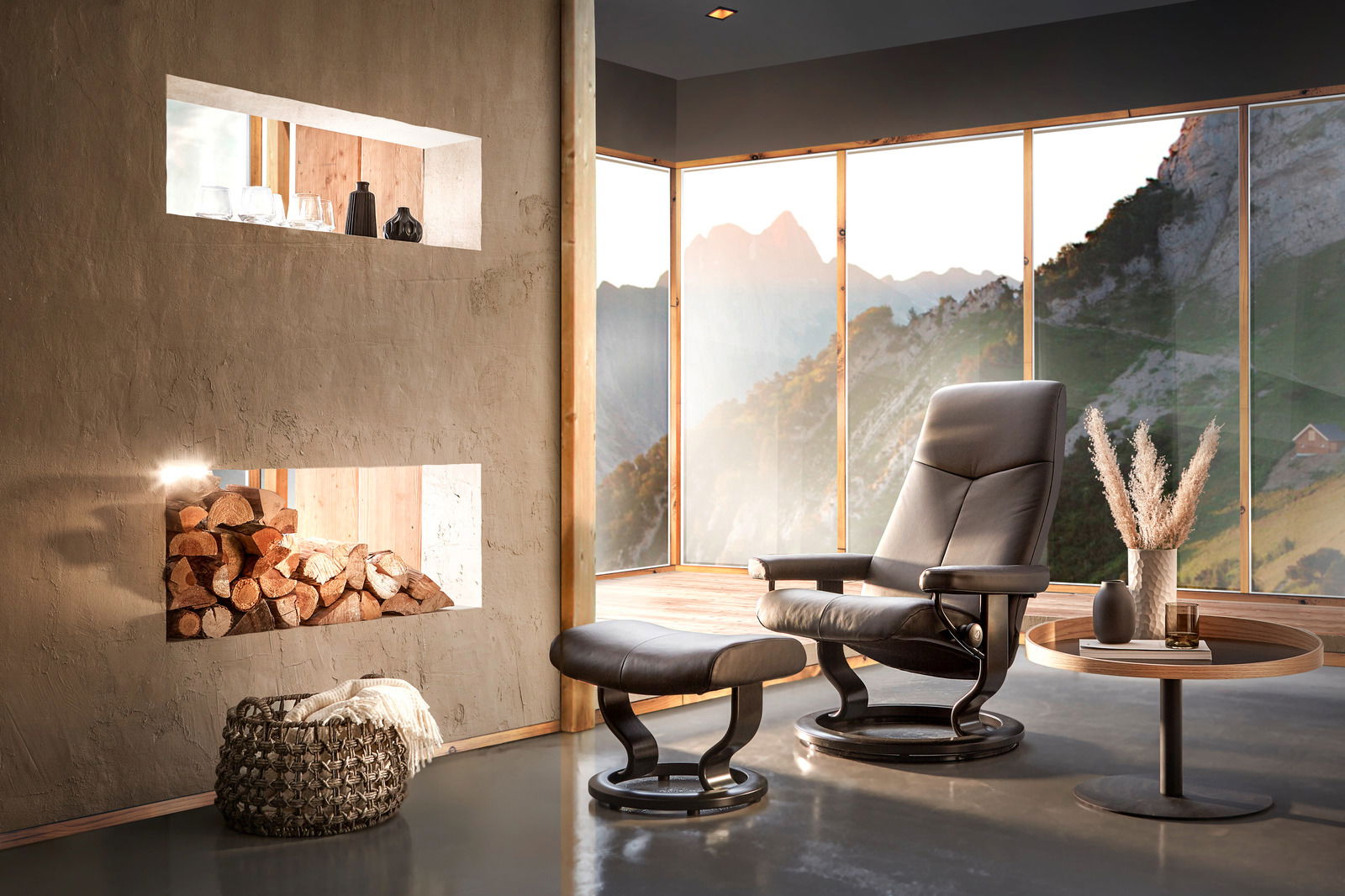 Moderner Einzelsessel mit Hocker in einem stilvollen Raum mit Panoramafenstern und Bergblick, seitliche Perspektive.