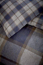 Nahaufnahme von kariertem Bettwäsche-Set in Blau- und Brauntönen, Perspektive von oben