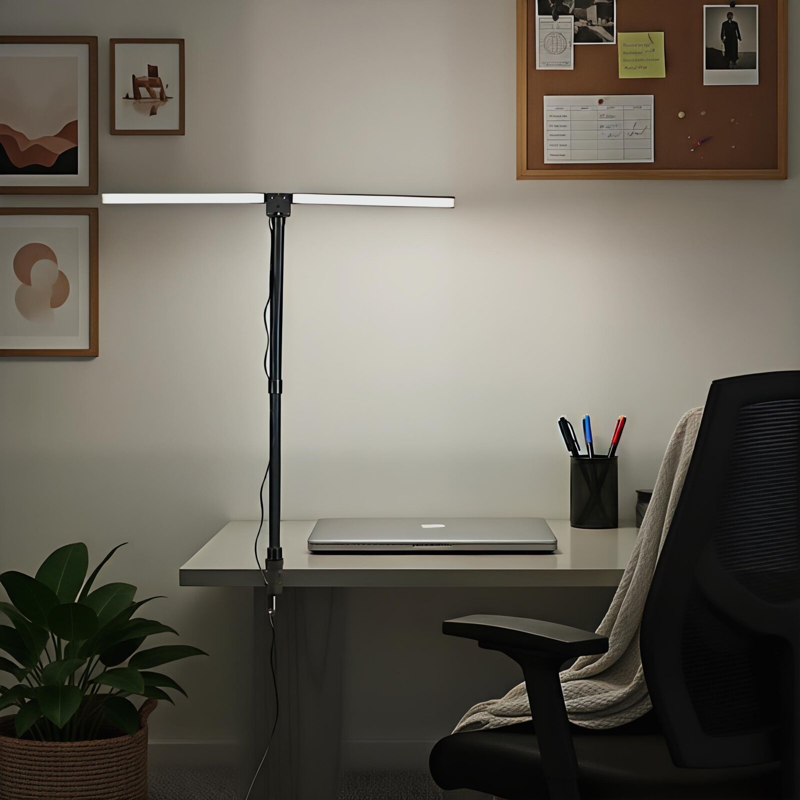 Schwarze, höhenverstellbare LED-Schreibtischlampe mit langem, horizontalem Lichtbalken am Arbeitsplatz neben Laptop und Stiftehalter, frontal auf Augenhöhe fotografiert.