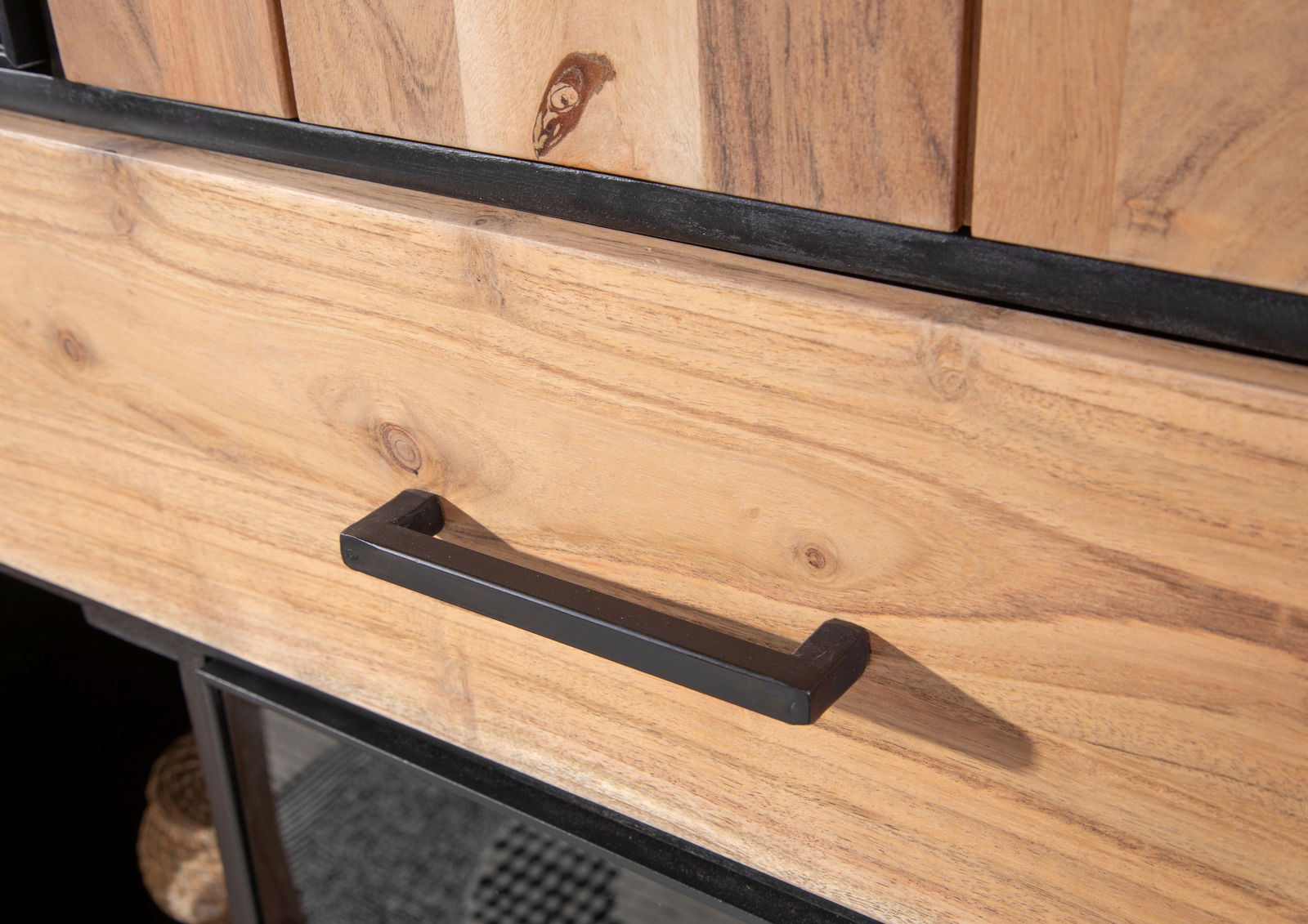 Nahaufnahme eines Highboards aus Holz mit schwarzem Griff, Perspektive von schräg oben