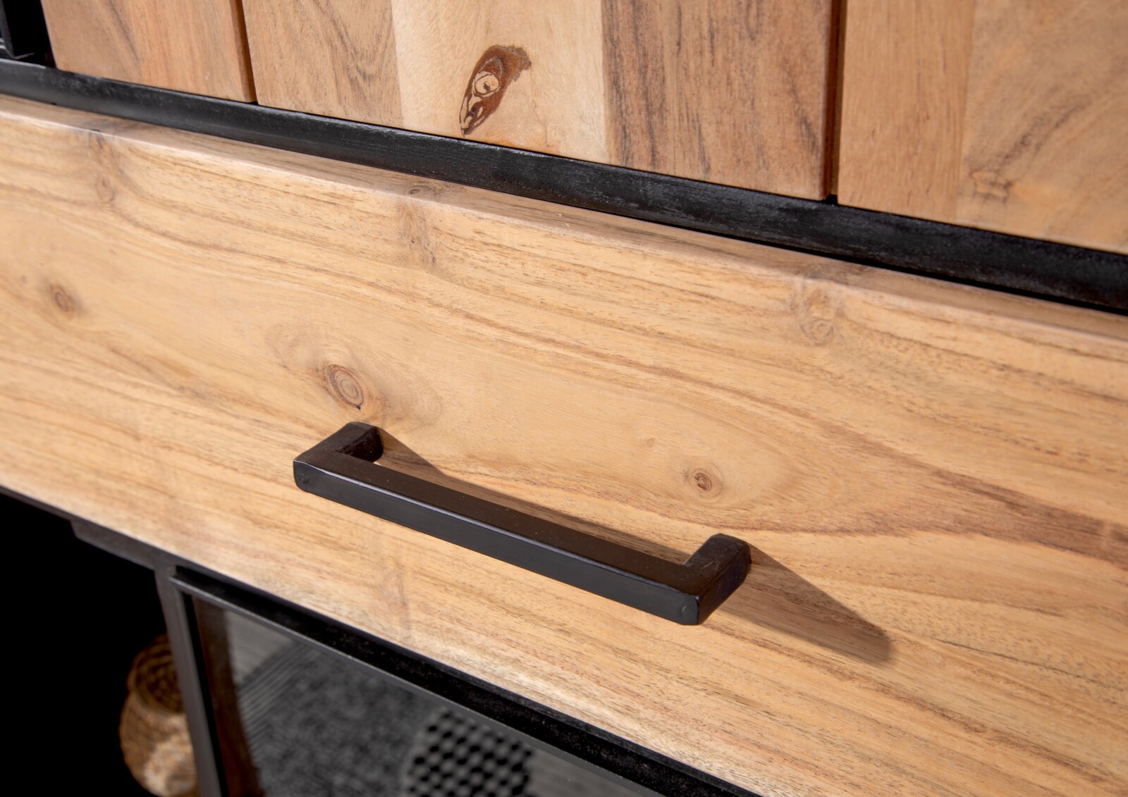 Nahaufnahme eines Highboards aus Holz mit schwarzem Griff, Perspektive von schräg oben