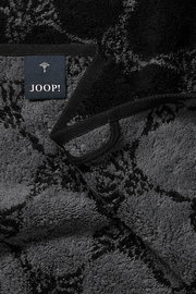 Nahaufnahme eines luxuriösen, dunkel gemusterten Handtuchs mit einem Joop!-Label.