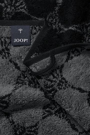 Nahaufnahme eines luxuriösen, dunkel gemusterten Handtuchs mit einem Joop!-Label.