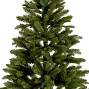 Close-up van een kunstkerstboom, een Tiaga-spar, met dichte groene takken, vanuit de zijkant gefotografeerd met perspectief.