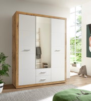 Kast met drie draaideuren in een moderne houtlook met witte fronten, hier afgebeeld in een lichte ruimte met grote ramen.