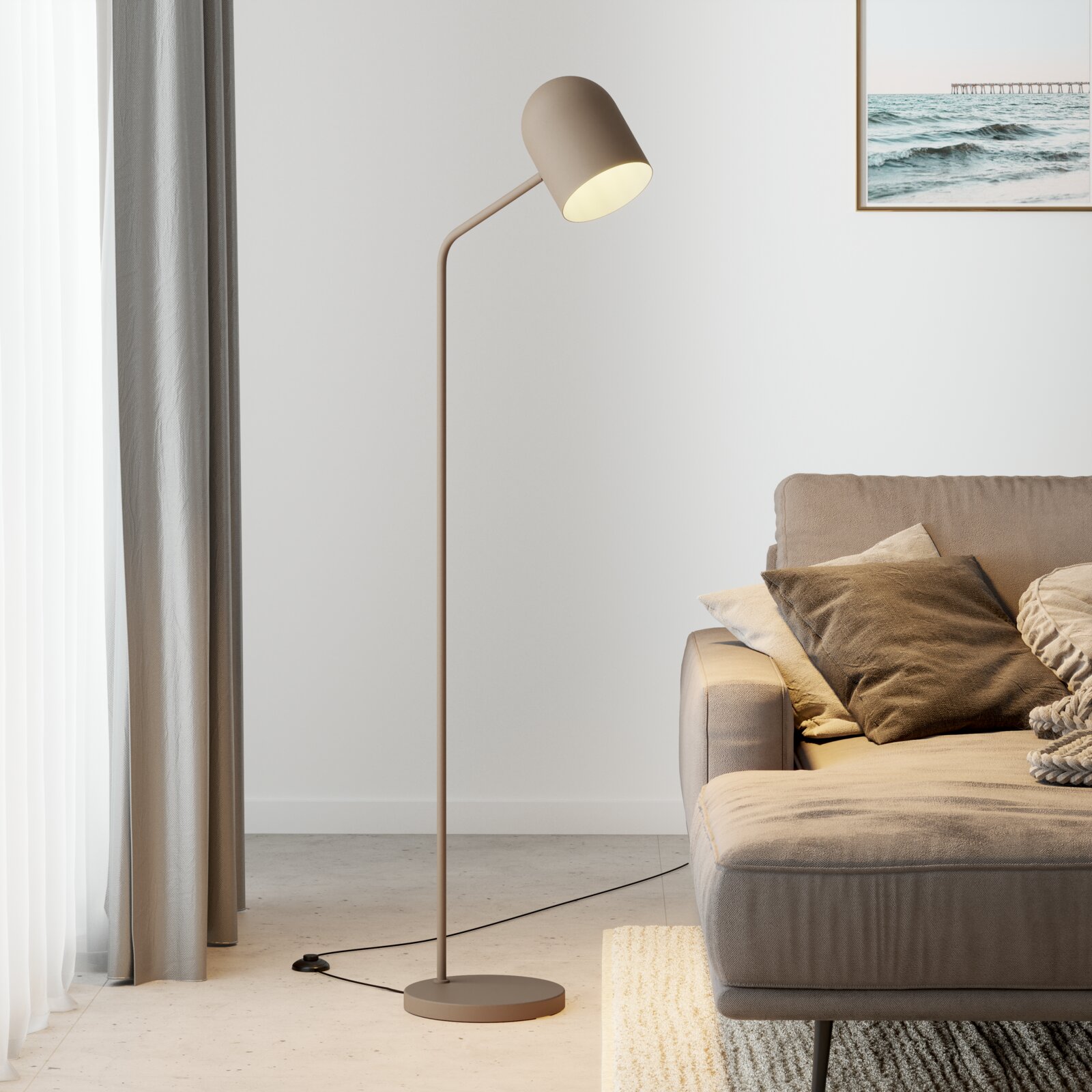 Moderne staande lamp in een woonkamer, zijaanzicht, naast een bank met kussens en een gordijn.