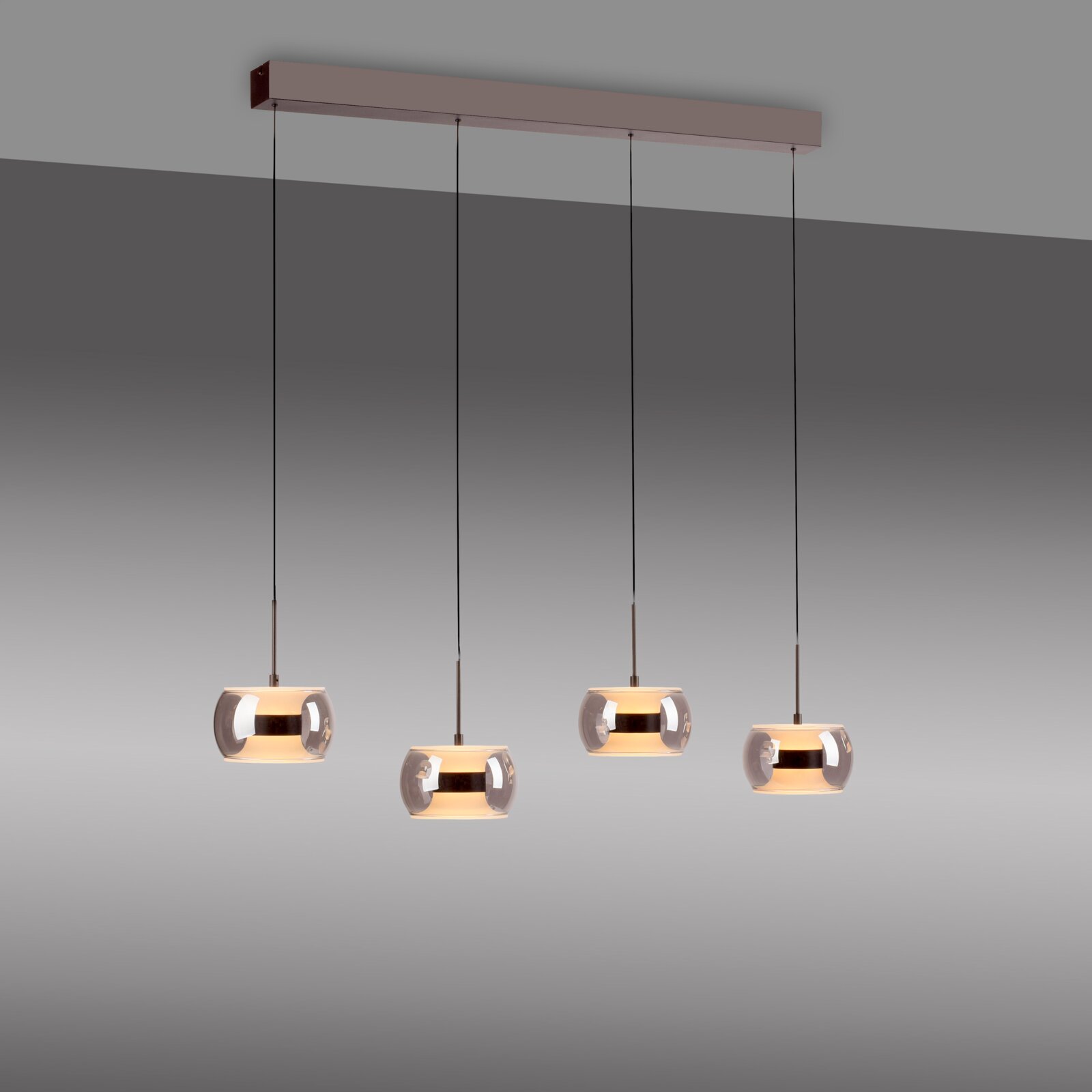 Moderne 4-flammige Pendelleuchte mit rechteckigem Deckenbalken und vier rauchgrauen Glas-Schirmen, warm leuchtend, Ansicht leicht von unten vor grauem Hintergrund
