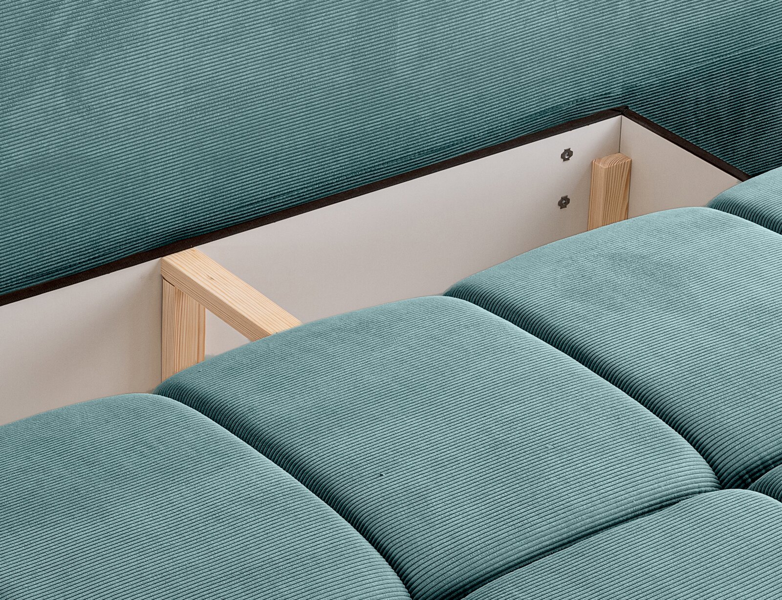 Nahaufnahme eines Schlafsofas mit türkisfarbenem Stoffbezug und sichtbarem Holzrahmen.