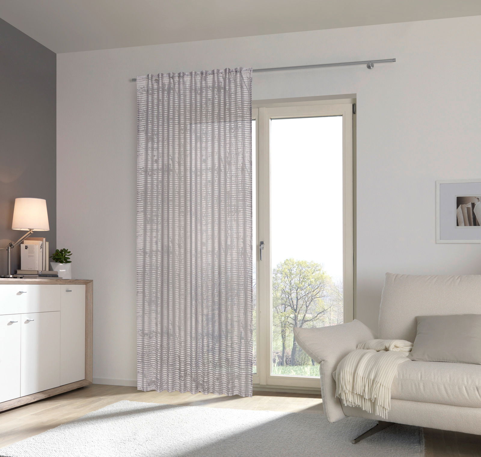 Fertigvorhang Giovanna 140x245 in einem modernen Wohnzimmer, frontal betrachtet, mit einem eleganten, wellenförmigen Muster vor einer großen Fensterfront.