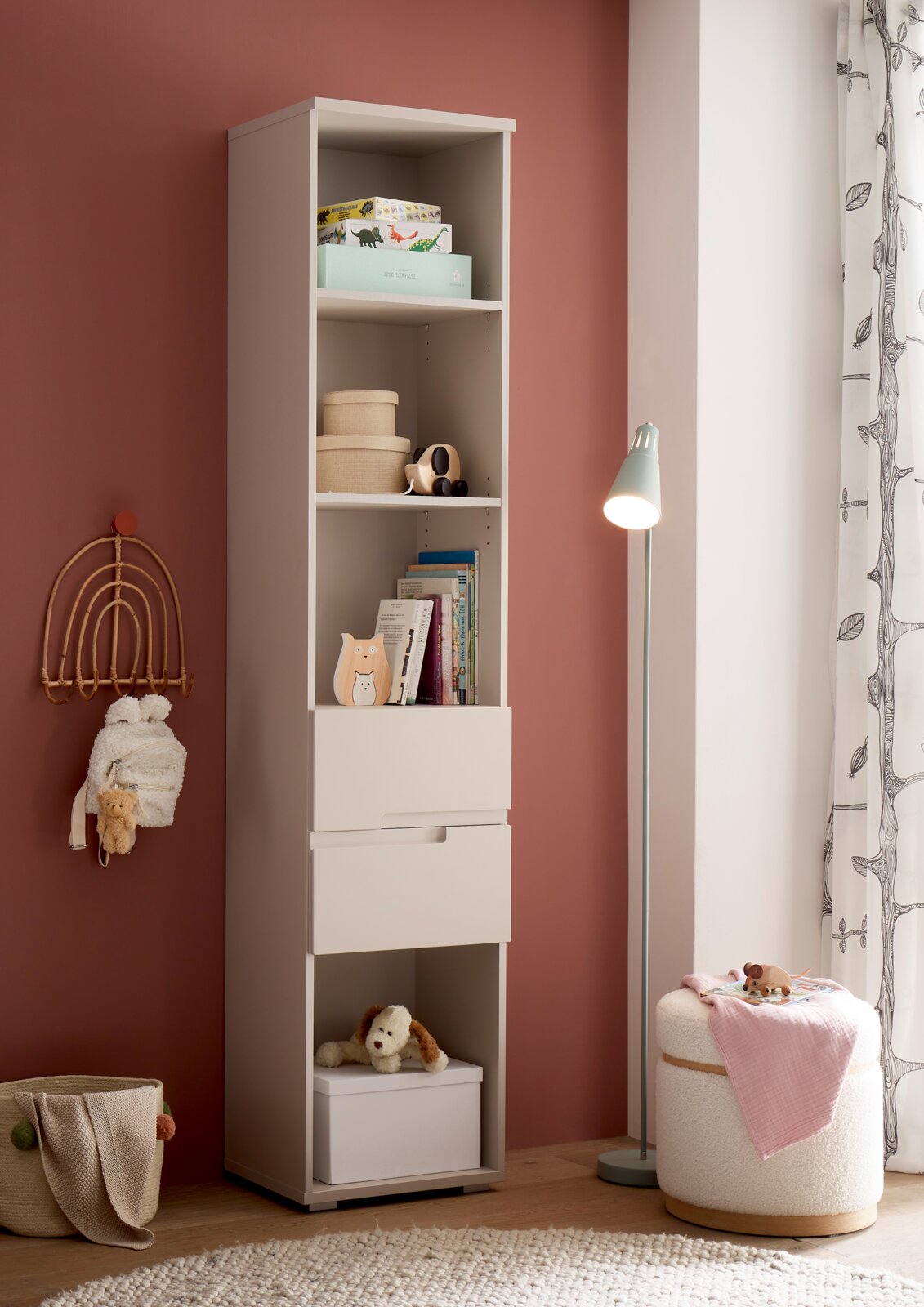 MyBaby Standregal SPICE/PEPPINI Hoher weißer Kinderzimmer-Regalschrank mit offenen Fächern und zwei Schubladen, mit Büchern und Spielzeug dekoriert, in leichter Schrägansicht von vorn vor rosafarbener Wand