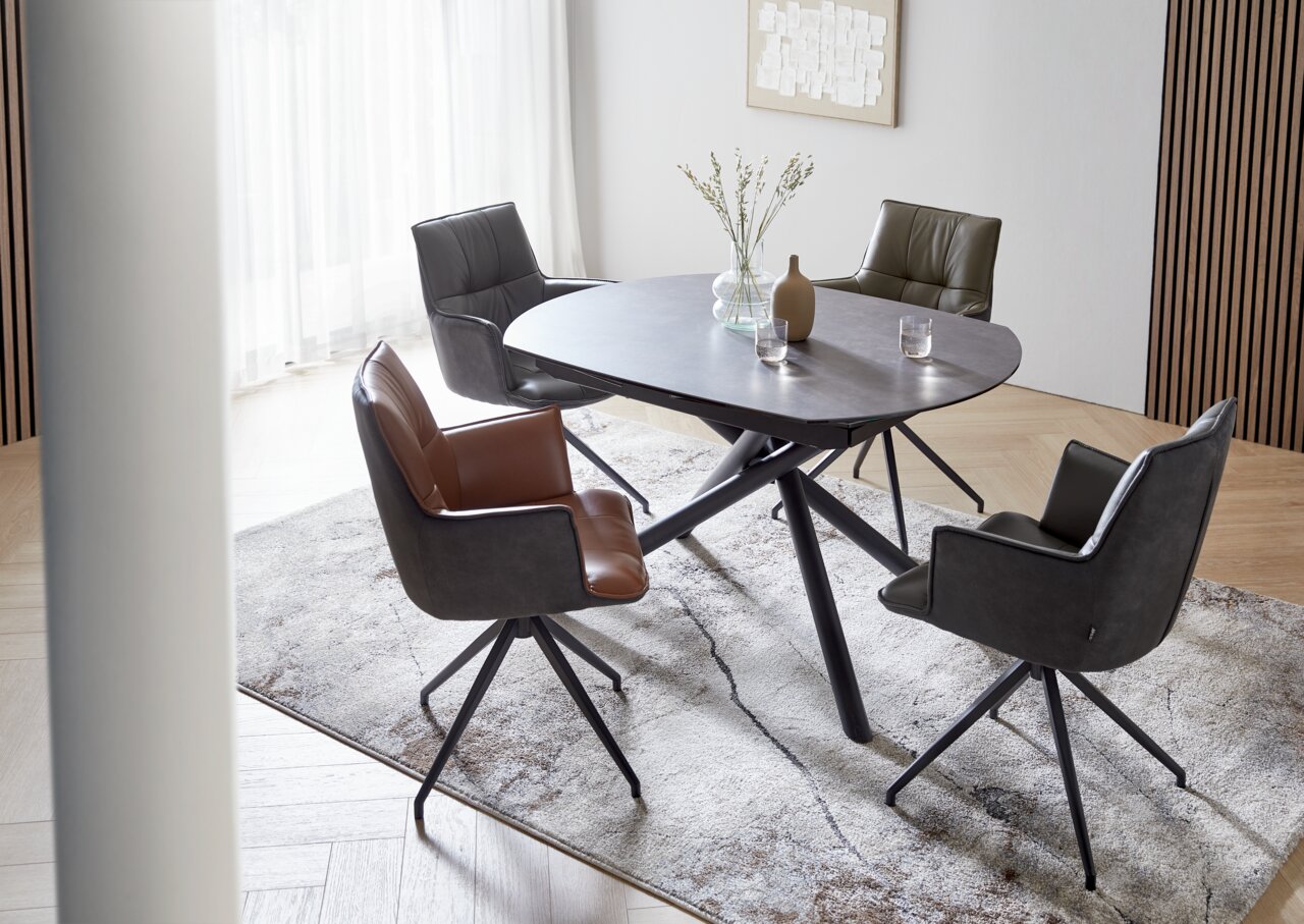 Moderner Esstisch mit vier Stühlen, aus der Vogelperspektive fotografiert, auf einem hellen Teppich in einem stilvollen Raum.