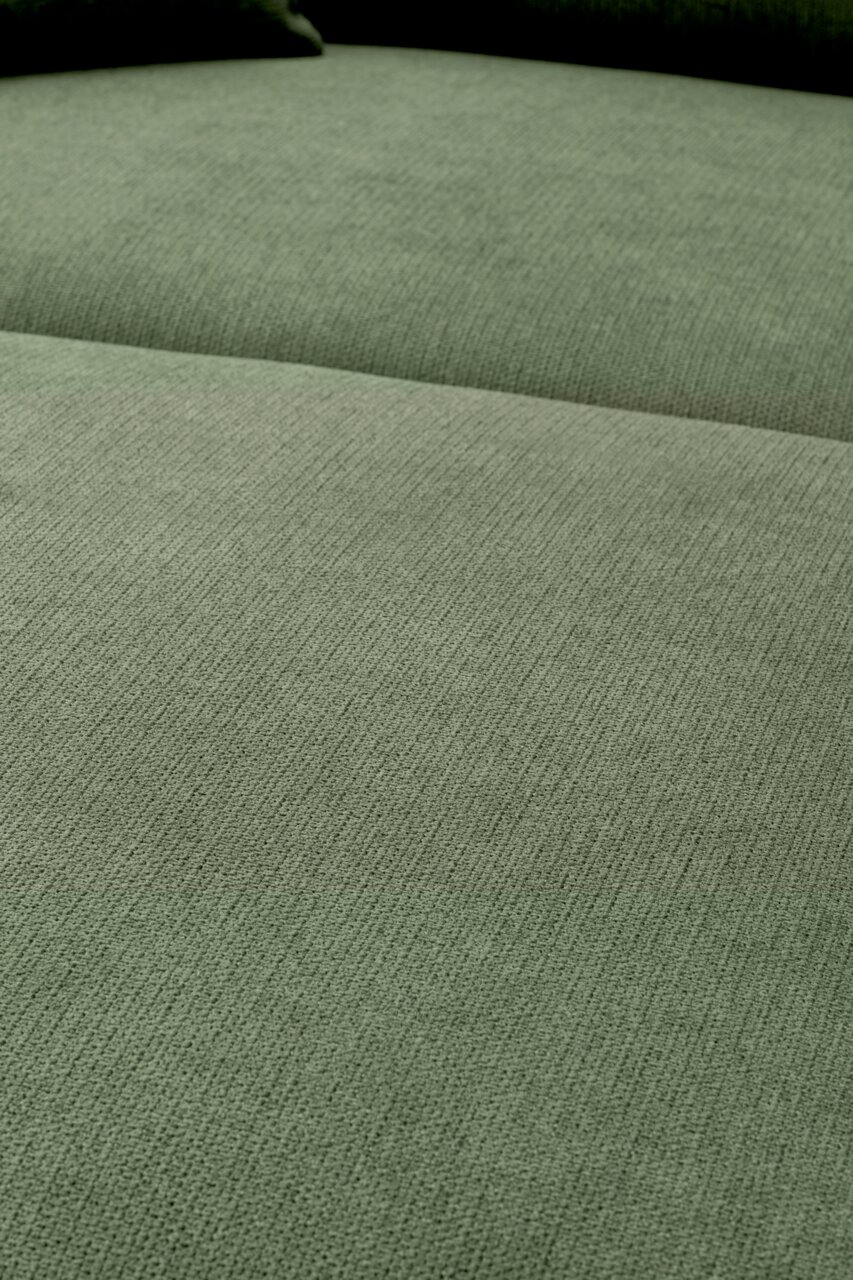 Close-up van de groen gemêleerde stoffen bekleding van een bank met zichtbare zitting en rugleuning, gefotografeerd vanuit een licht schuin bovenaanzicht.
