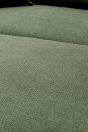 Close-up van de groen gemêleerde stoffen bekleding van een bank met zichtbare zitting en rugleuning, gefotografeerd vanuit een licht schuin bovenaanzicht.