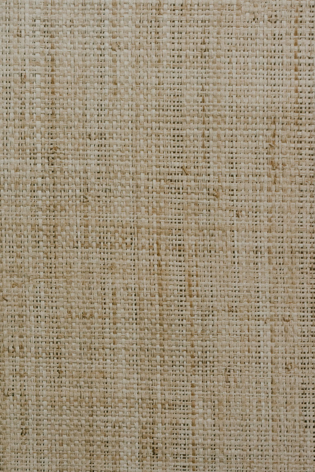 Nahaufnahme einer gewebten Textur in natürlichen Beigetönen, von oben betrachtet.
