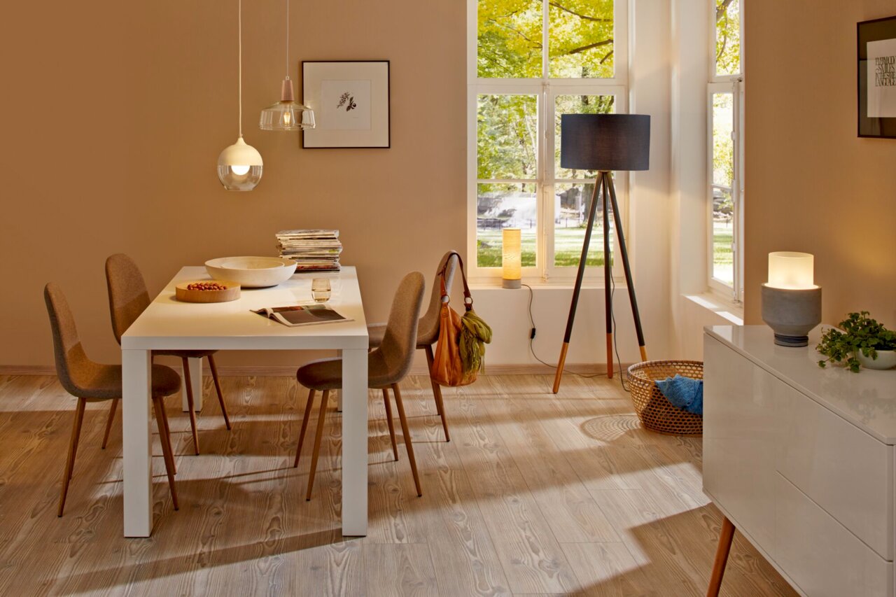 Gezellige eetkamer met moderne ledverlichting, waaronder een hanglamp boven de tafel en een staande lamp in de hoek, gezien vanuit de kamer.