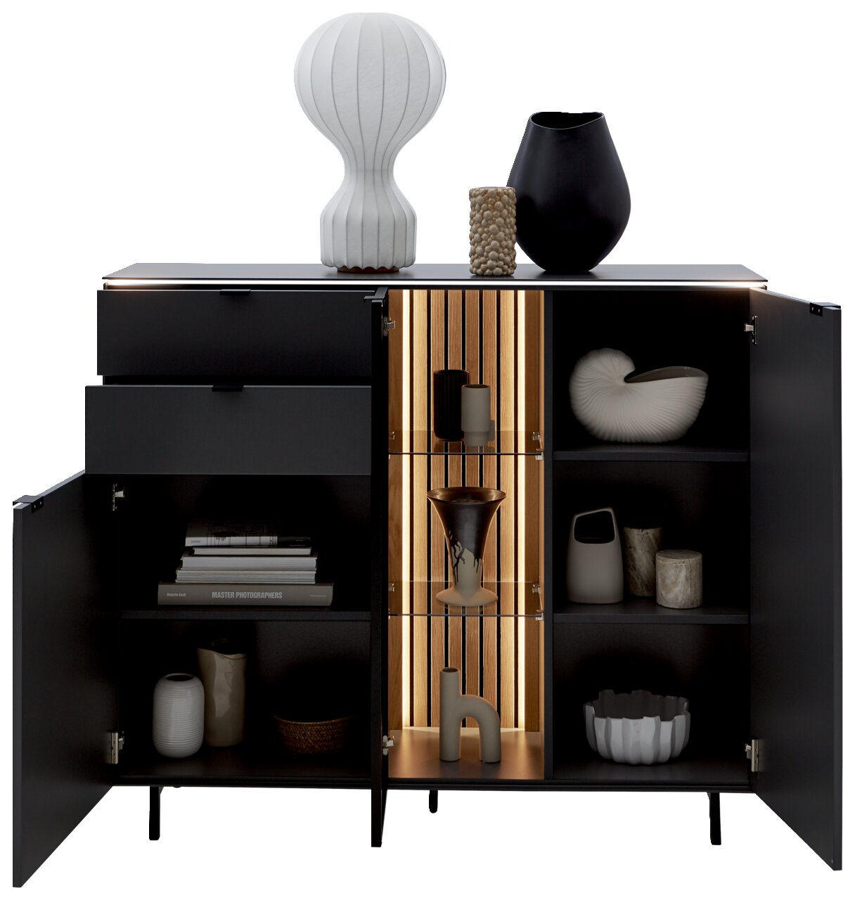 Vooraanzicht van het Dieter Knoll-hoogkastmodel RIANI met geopende deur, versierd met vazen en boeken, verlichte binnenplank.