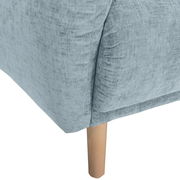 Nahaufnahme einer hellblauen Sofaecke mit Holzbein, Perspektive von unten.