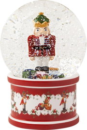 Große Schneekugel mit Nussknacker, frontal abgebildet, auf rotem Sockel mit weihnachtlichen Motiven.