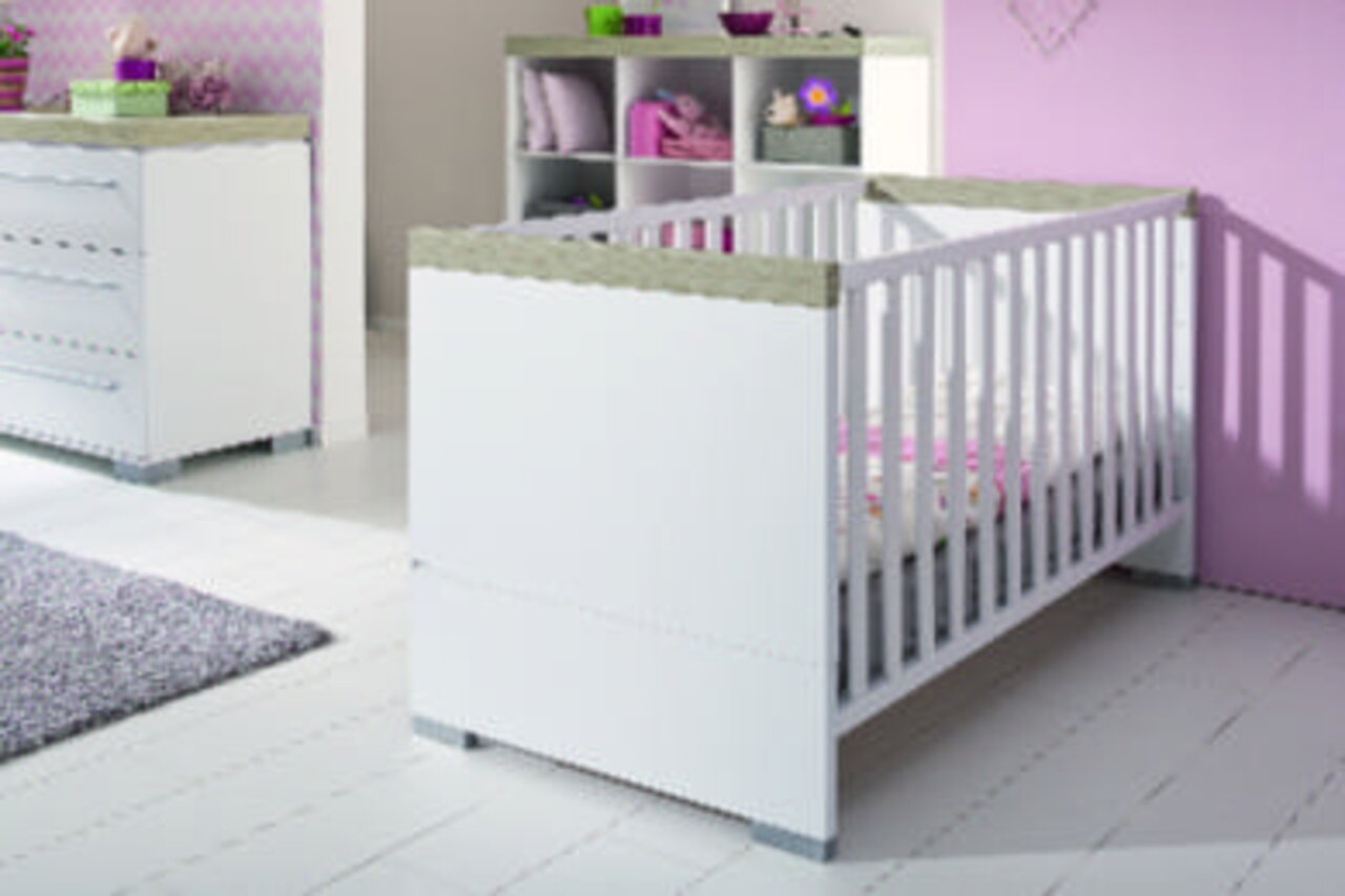 Weißes Babybett in einem Babyzimmer, seitliche Perspektive