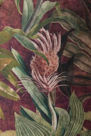 Nahaufnahme eines Lampenschirms mit tropischem Pflanzenmuster in grünen und roten Tönen.