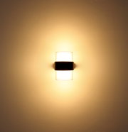 LED-Außenwandleuchte, frontal an der Wand montiert, mit warmem Lichtschein.