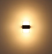 LED-Außenwandleuchte, frontal an der Wand montiert, mit warmem Lichtschein.