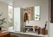 Moderne Garderobenkombination mit weißem Schrank, hölzerner Wandgarderobe, Spiegel und Sitzbank mit Kissen, seitliche Perspektive.