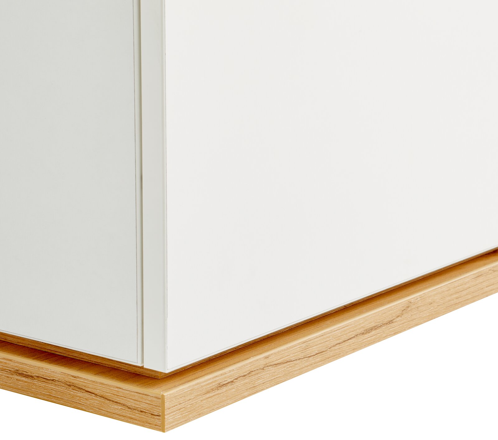 Nahaufnahme einer weißen Kommode mit Holzsockel, seitliche Perspektive.