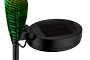 Close-up van een zonne-lamp met een groen bladmotief en een zwart zonnepaneel, gezien vanaf de zijkant.