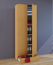 Hoher, schmaler Kleiderschrank in heller Holzoptik mit zwei Türen und ausziehbarer Schublade unten, teilweise geöffnet und mit gefalteter Kleidung sowie Ordnern gefüllt, perspektivische Frontansicht leicht von links.