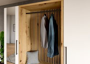 Kompaktgarderobe aus Holz mit zwei aufgehängten Hemden und einem Kissen, frontal betrachtet.