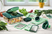 Nicer Dicer Chef 15-teiliges Set in einer Küchenumgebung, mit verschiedenen Schneideinsätzen und einem Behälter voller geschnittener Gemüsewürfel, aus der Perspektive von vorne.